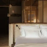 Luxurious bedroom at eriro Alpine Hide with white linen bedding, wool headboard and floating crystal lights of natural stone