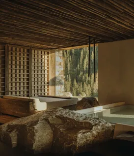 eriro wellness with soaking pool, raw boulder, branch wood ceiling grid and Wetterstein panorama window through Japanese wood slat door